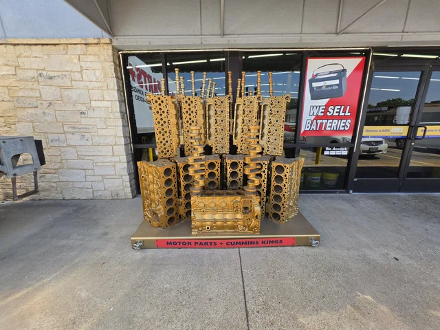 Gold Cummins Kings engine-component display outside Motor Parts +